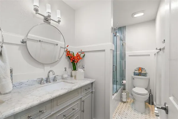 a bathroom with a granite countertop sink a toilet and a mirror