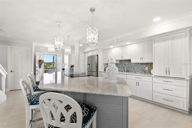 a large kitchen with kitchen island a chandelier and living room view