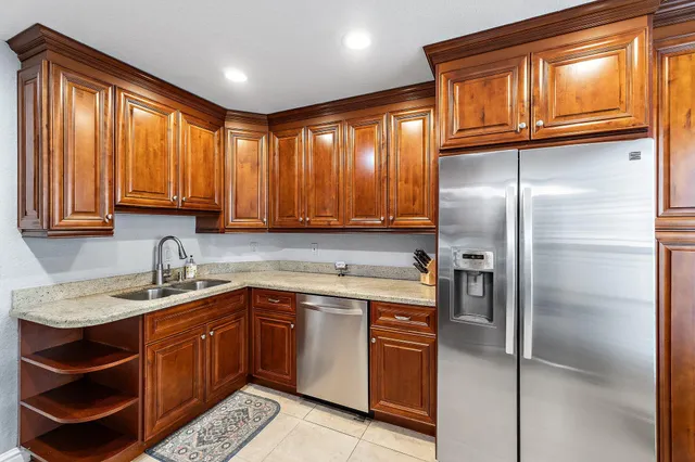 a kitchen with a sink refrigerator and cabinets