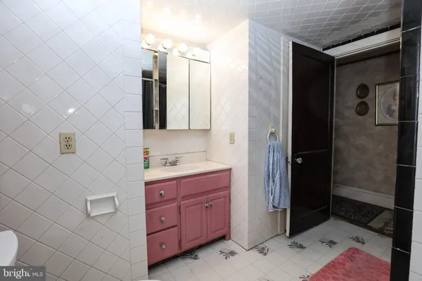 a bathroom with a granite countertop sink a mirror and shower
