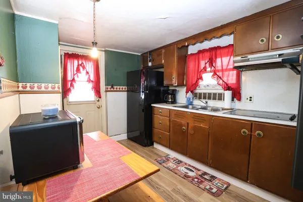 a kitchen with stainless steel appliances granite countertop a refrigerator stove top oven and cabinets