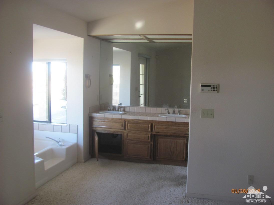 7078 Cascade Road Joshua Tree, CA 92252 - Photo 14 of 21 a bathroom with a double vanity sink and mirror with shower