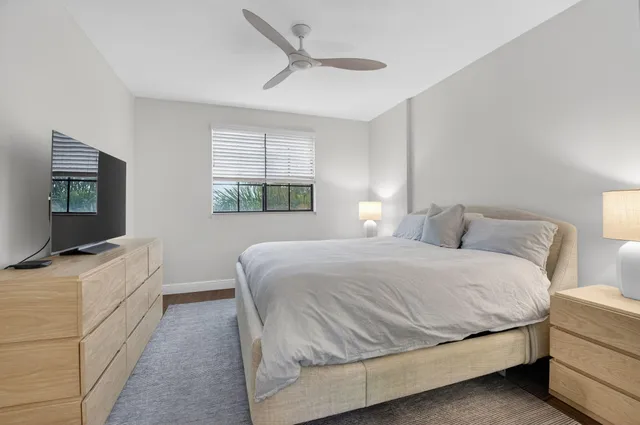 a spacious bedroom with a bed and a flat screen television