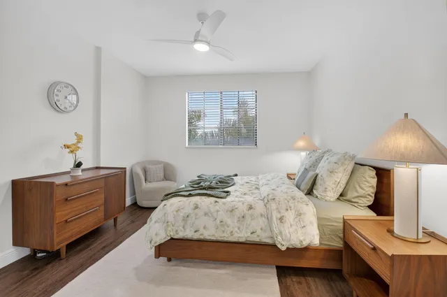 a bedroom with a bed and a lamp on dresser