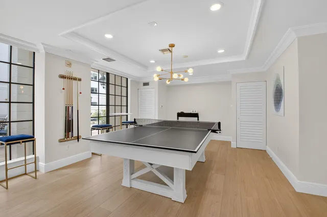 a living room with furniture a floor to ceiling window and wooden floor