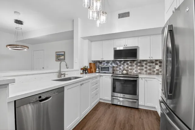 a kitchen with a sink stainless steel appliances and cabinets