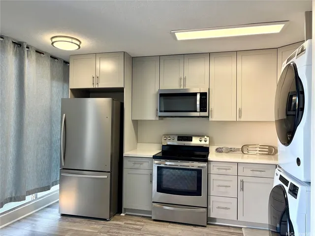 a kitchen with a refrigerator and a stove top oven