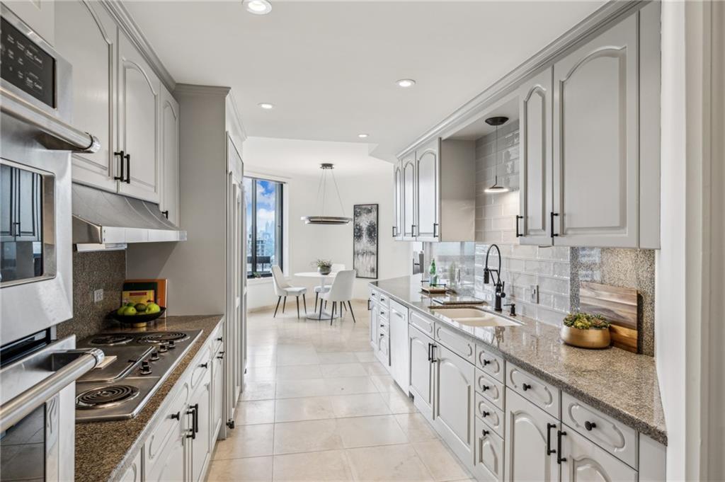 2660 Peachtree Road Northwest, Unit 23A Atlanta, GA 30305 - Photo 14 of 56 a kitchen with stainless steel appliances a sink stove and cabinets