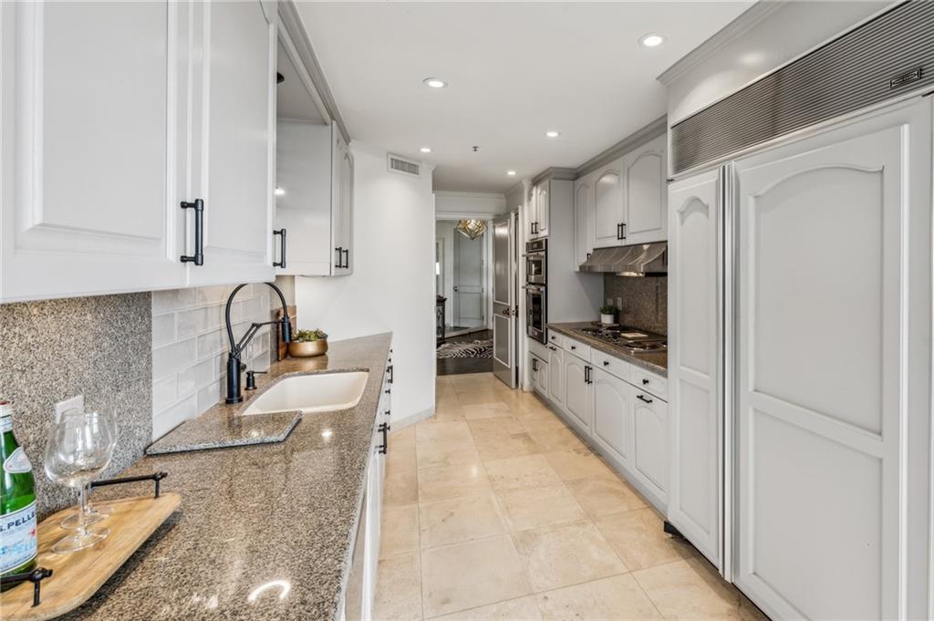 2660 Peachtree Road Northwest, Unit 23A Atlanta, GA 30305 - Photo 15 of 56 a large kitchen with kitchen island a counter top stainless steel appliances and cabinets