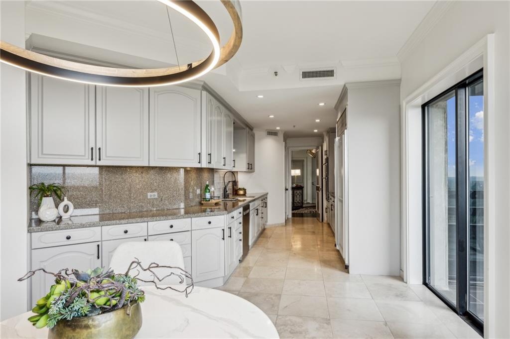 2660 Peachtree Road Northwest, Unit 23A Atlanta, GA 30305 - Photo 18 of 56 a kitchen with white cabinets and chandelier