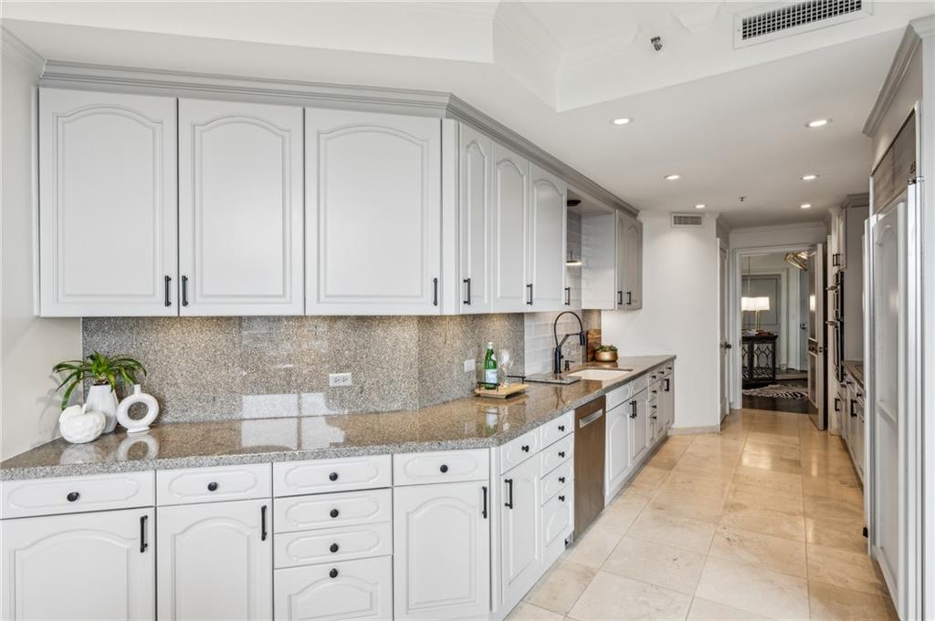 2660 Peachtree Road Northwest, Unit 23A Atlanta, GA 30305 - Photo 19 of 56 a kitchen with granite countertop white cabinets and stainless steel appliances