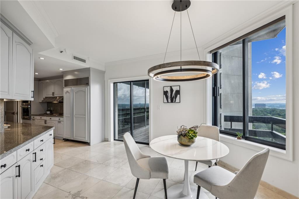 2660 Peachtree Road Northwest, Unit 23A Atlanta, GA 30305 - Photo 20 of 56 a kitchen with stainless steel appliances a dining table chairs and white cabinets