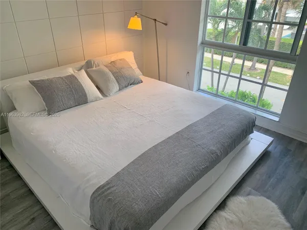 a bed sitting in a bedroom next to a large window