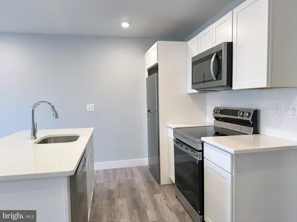 a kitchen with stainless steel appliances granite countertop a sink stove and microwave