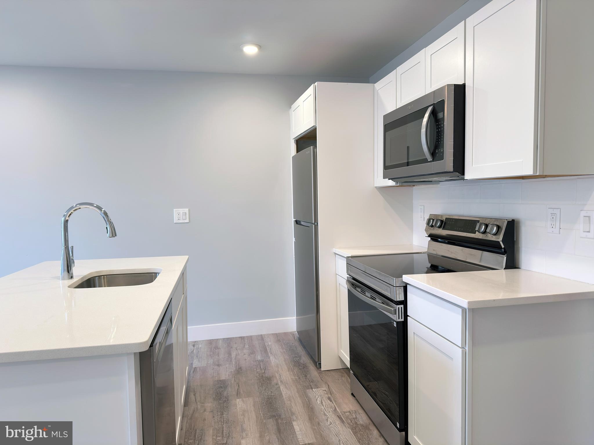 2809 South Warnock Street Philadelphia, PA 19148 - Photo 4 of 17 a kitchen with stainless steel appliances granite countertop a sink stove and microwave