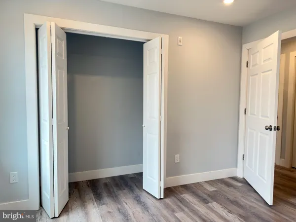 a view of a closet area with hardwood floor