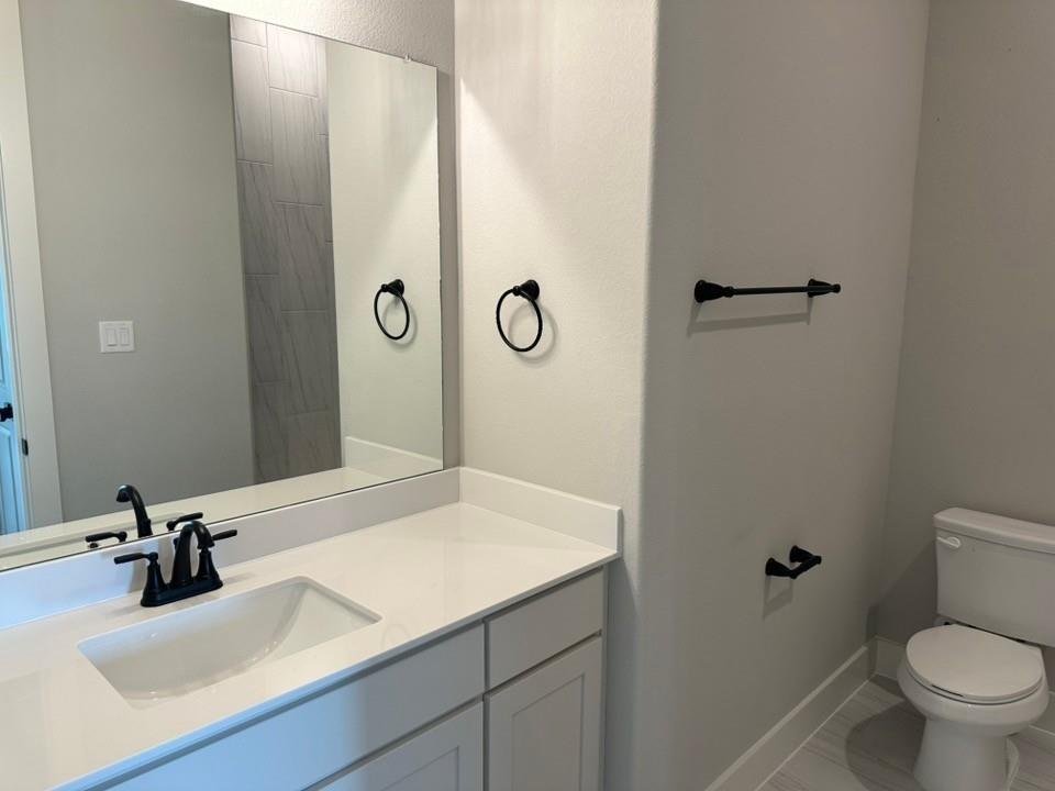 390 Cobb Road Leonard, TX 75452 - Photo 8 of 26 Bathroom vanity with a rectangular undermount sink, solid surface countertop, and matte black hardware