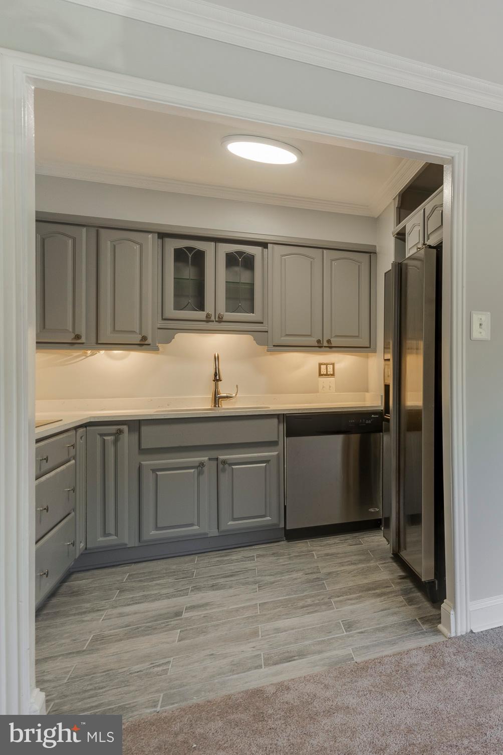 6141 Edsall Road, Unit H Alexandria, VA 22304 - Photo 9 of 29 a kitchen with stainless steel appliances granite countertop a sink and dishwasher a stove top oven with wooden floor