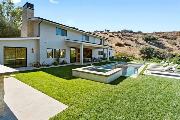 a view of a house with swimming pool and a yard