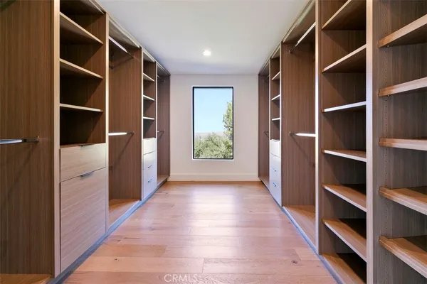 a view of a hallway with bathroom and mirror