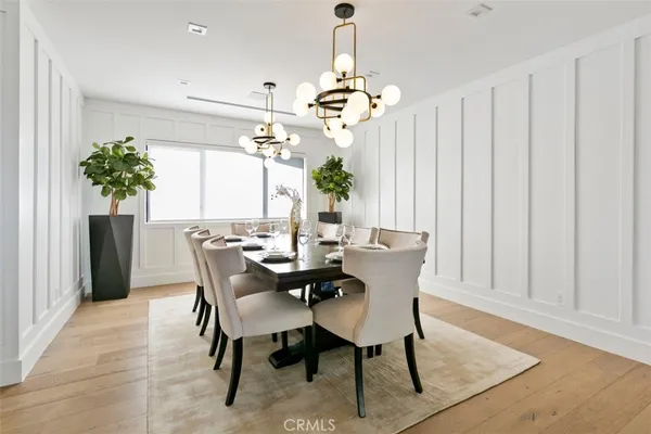a dining room with furniture potted plants and wooden floor