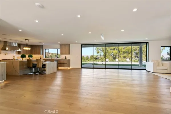 a view of an empty room with furniture and a large window