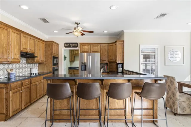 a kitchen with stainless steel appliances a dining table and chairs