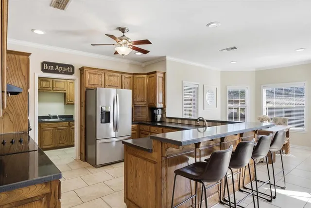 a kitchen with granite countertop a table chairs refrigerator and microwave