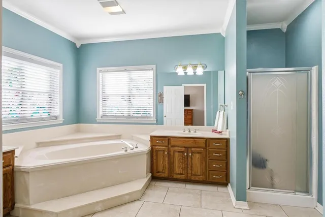 a spacious bathroom with a tub sink and mirror