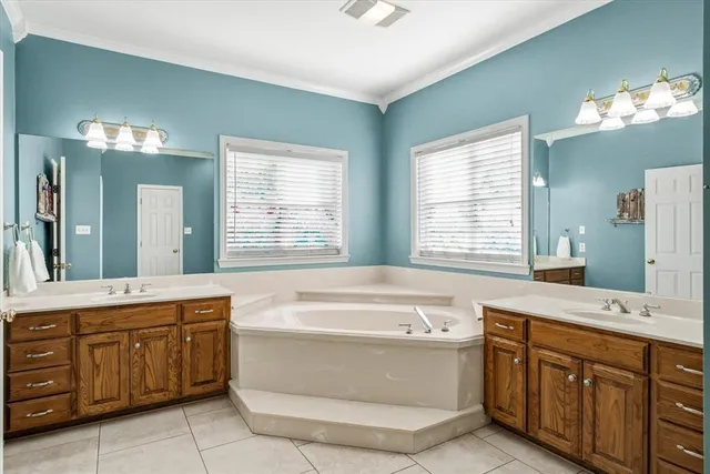 a bathroom with a tub sink and mirror