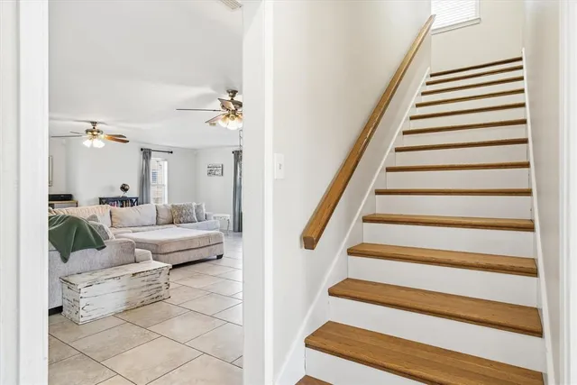 a living room with furniture and a ceiling fan