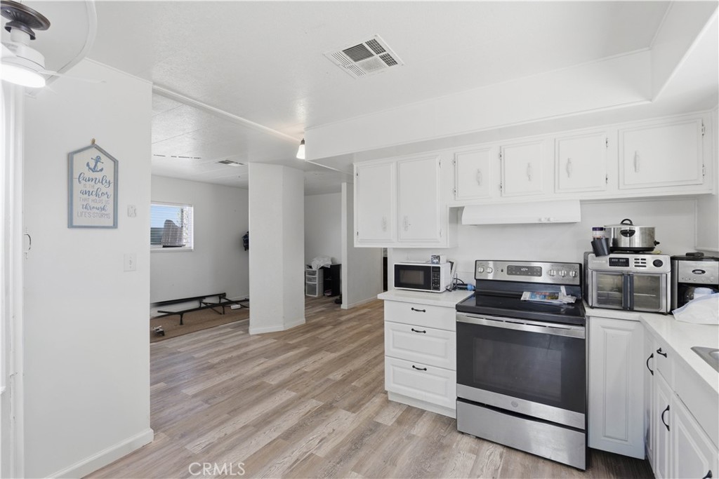 5885 Dos Palmas Road Phelan, CA 92371 - Photo 13 of 40 a kitchen with granite countertop white cabinets and white appliances