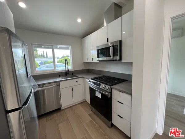 a kitchen with stainless steel appliances granite countertop a stove a sink and a microwave