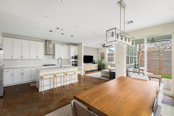 a open kitchen with kitchen island a large counter top space a sink stainless steel appliances and cabinets