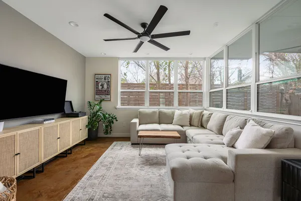 a living room with furniture a flat screen tv and a large window