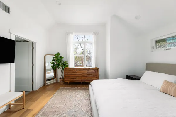 a bedroom with a bed and a potted plant