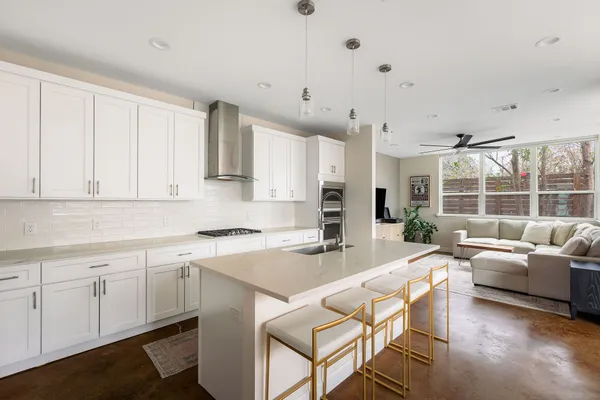 a kitchen with a sink white cabinets and stainless steel appliances
