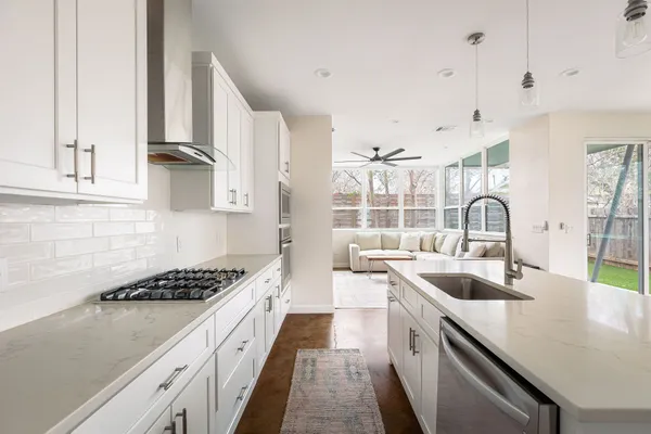 a kitchen with kitchen island stainless steel appliances a sink stove and cabinets