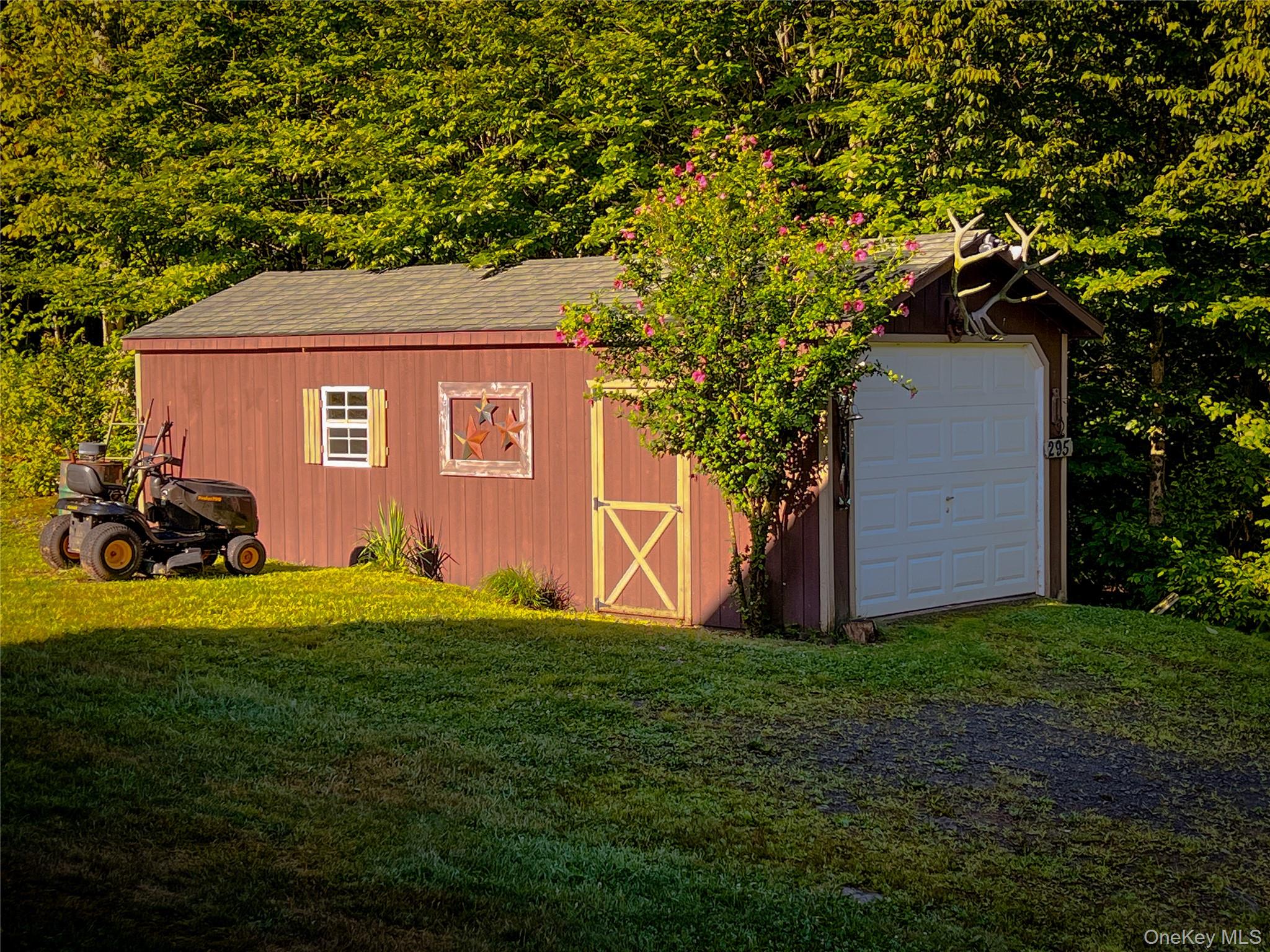 295 Emerald Heights Road Delancey, NY 13752 - Photo 7 of 30 Red-sided outbuilding with asphalt shingle roof, white garage door, and yellow trim