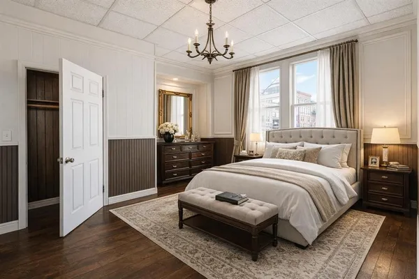 a bedroom with a large bed and a chandelier