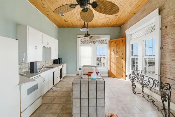 a view of a dining room with furniture a chandelier and kitchen view