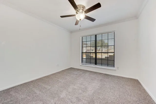 an empty room with a window and a ceiling fan