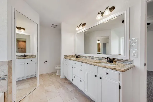 a bathroom with double sink and a mirror