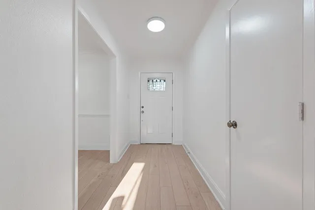 a view of a hallway with wooden floor