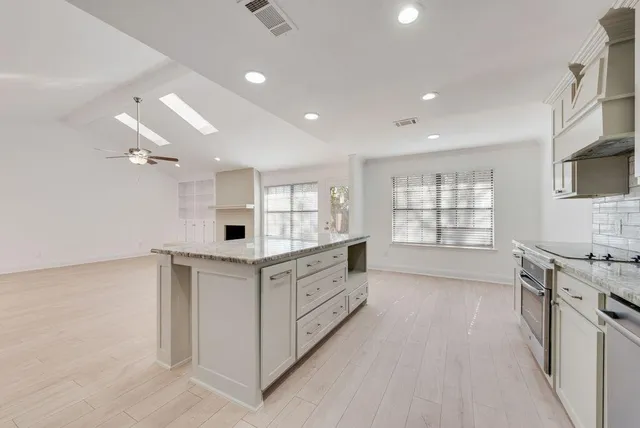 a kitchen with stainless steel appliances a sink stove and cabinets