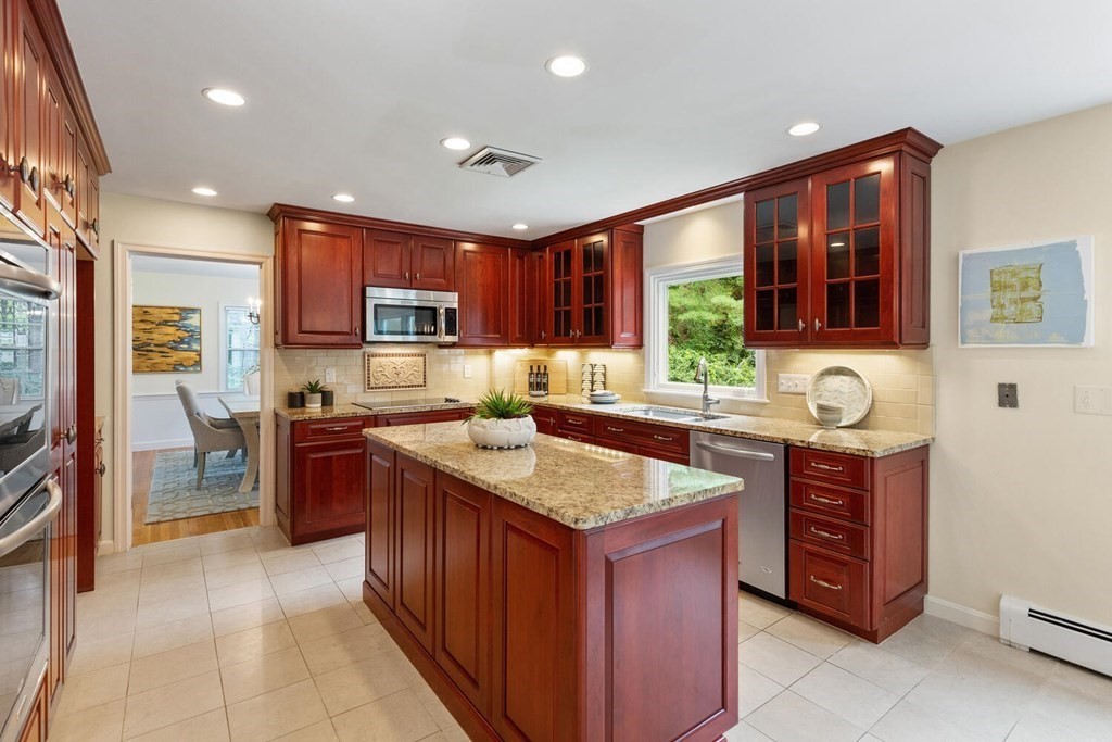 29 Saddle Club Road Lexington, MA 02420 - Photo 5 of 22 a kitchen with stainless steel appliances granite countertop wooden cabinets a stove a sink and a refrigerator