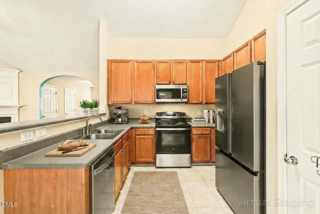 a kitchen with stainless steel appliances granite countertop a refrigerator a stove and a sink