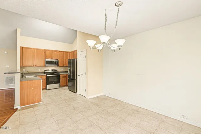 a kitchen with a refrigerator a stove and a sink