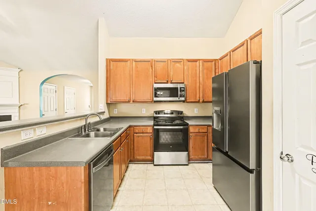 a kitchen with stainless steel appliances granite countertop a refrigerator and a sink