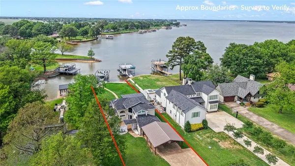 an aerial view of a house with outdoor space and lake view